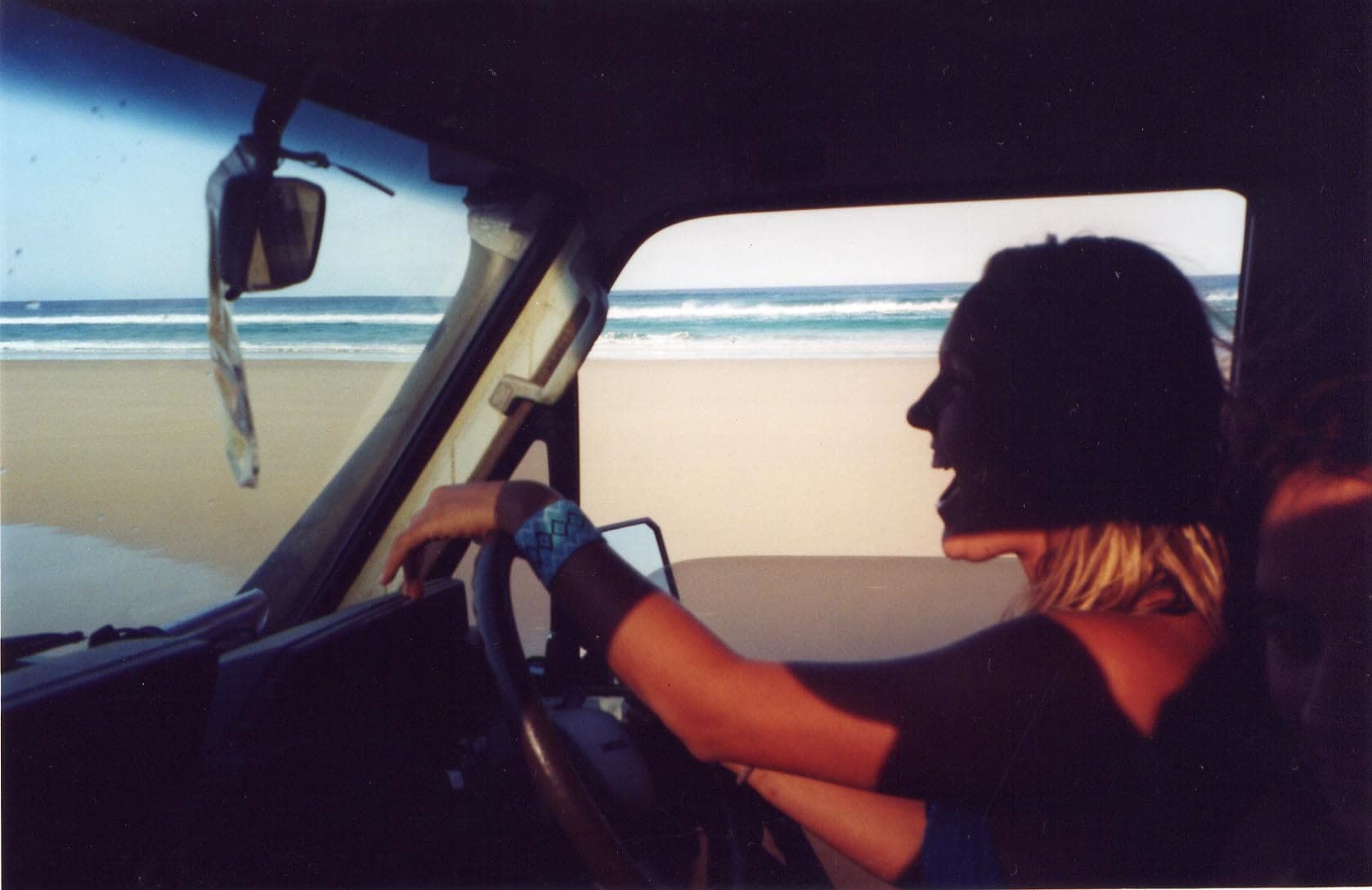 A four wheel drive on the beach at K'gari with the surf alongside