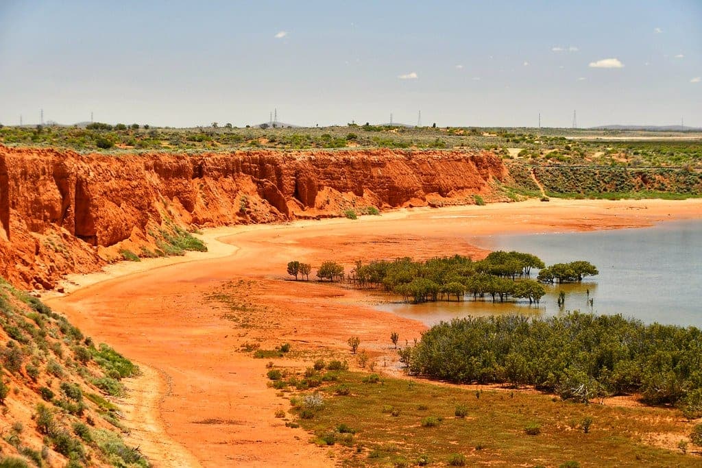 Red cliffs above water in arid country