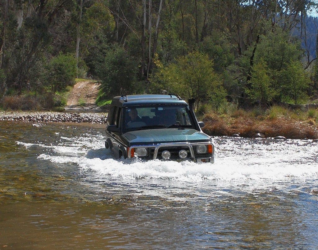 A four wheel drive crossing a river